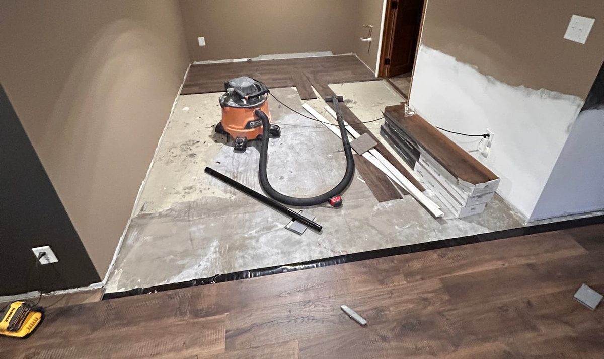 Before: the same Grandville room stripped back to the subfloor during prep